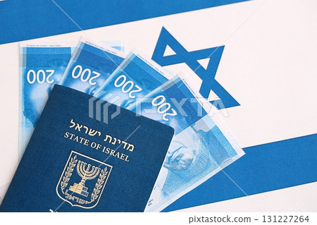 Israel New Shekels banknotes and passport on flag. The current Israel money bills and pass 131227264