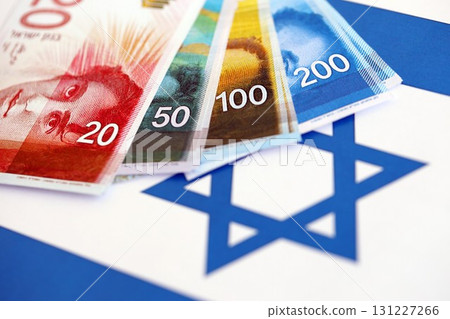 Israel New Shekels banknotes on national flag. The current Israel money bills lies on flag 131227266