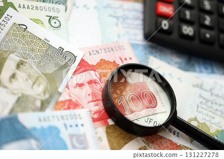 Pakistan rupees banknotes and calculator with magnifying glass. Pakistan money bills calc with loupe Pakistan rupees banknotes and calculator with magnifying glass. Pakistan money bills calc with loupe 131227278