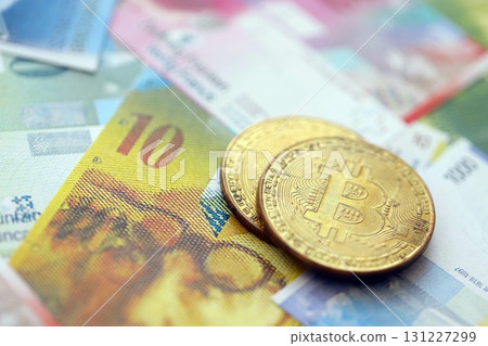 Swiss franc banknotes and bitcoin. The current francs money bills and bit coin lies on table Swiss franc banknotes and bitcoin. The current francs money bills and bit coin lies on table 131227299