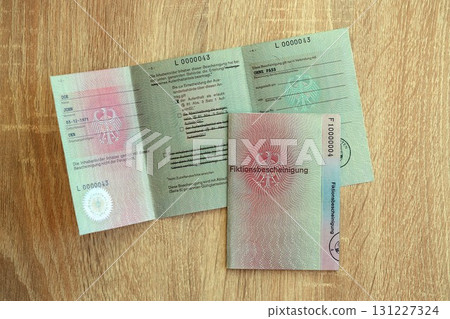 German temporary Permanent resident card lies on wooden table. Fiktionsbescheinigung 131227324