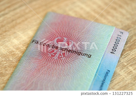 German temporary Permanent resident card lies on wooden table. Fiktionsbescheinigung 131227325