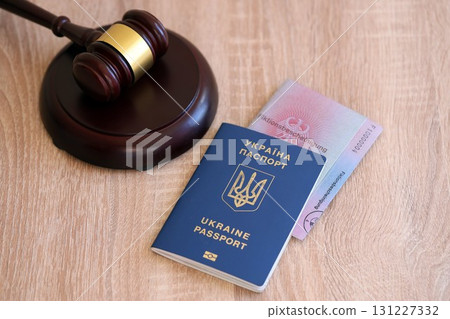 German temporary Permanent resident card and Ukrainian passport lies with judge hammer 131227332