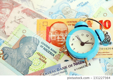 Nigerian naira currency money bills and alarm clock. The concept of time management and income Nigerian naira currency money bills and alarm clock. The concept of time management and income 131227364