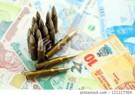 Nigerian naira currency money bills and rifle bullets. The concept of warfare and gun selling 131227369