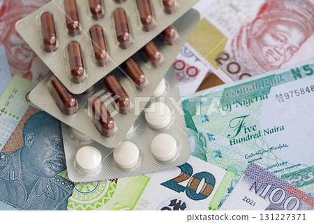 Nigerian naira currency money bills and medicine pills. The concept of medicine and pharmacy Nigerian naira currency money bills and medicine pills. The concept of medicine and pharmacy 131227371