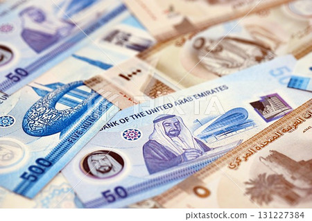 United Arab Emirates dirham currency money bills. The current banknotes lies on table in big amount United Arab Emirates dirham currency money bills. The current banknotes lies on table in big amount 131227384