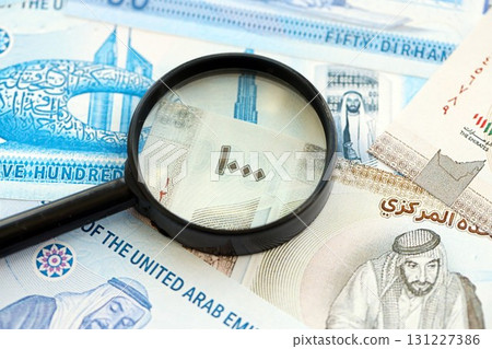 United Arab Emirates dirham currency money bills and magnifying glass. The concept of financial monitoring and taxation United Arab Emirates dirham currency money bills and magnifying glass. The concept of financial monitoring and taxation 131227386