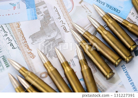 United Arab Emirates dirham currency money bills and rifle bullets. The concept of warfare and gun selling United Arab Emirates dirham currency money bills and rifle bullets. The concept of warfare and gun selling 131227391