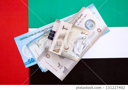 United Arab Emirates dirham currency money bills lies on flag. The concept of business and investment 131227402