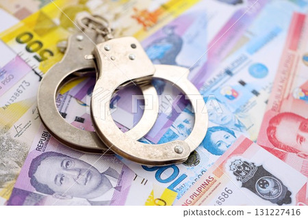 Philippines peso currency money bills and handcuffs. The concept of criminal Philippines peso currency money bills and handcuffs. The concept of criminal 131227416