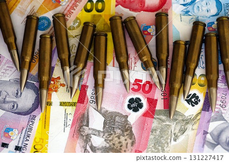 Philippines peso currency money bills and rifle bullets. The concept of warfare and gun selling 131227417