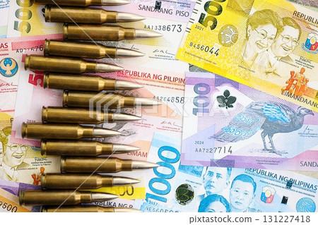 Philippines peso currency money bills and rifle bullets. The concept of warfare and gun selling 131227418