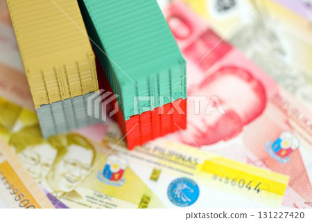 Philippines peso currency money bills and toy cargo containers. The concept of shipping and logistics Philippines peso currency money bills and toy cargo containers. The concept of shipping and logistics 131227420