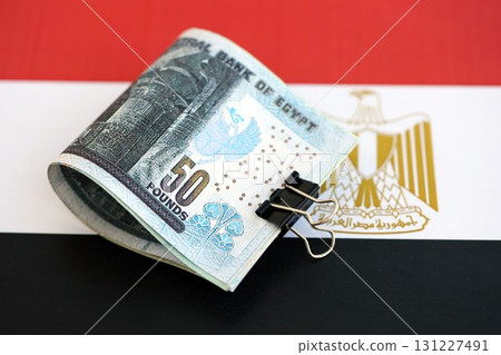 Egyptian pound currency money bills lies on flag. The concept of business and investment Egyptian pound currency money bills lies on flag. The concept of business and investment 131227491