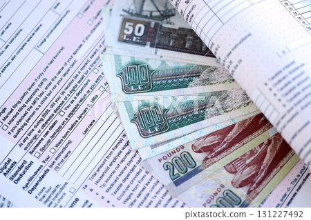 Egyptian pound money bills on tax form. Taxation and accounting concept 131227492