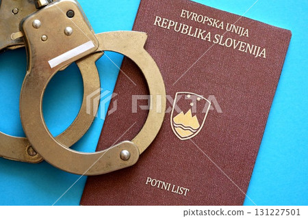 Slovenia passport with police handcuffs on table. Criminal level and arrests in Europe 131227501