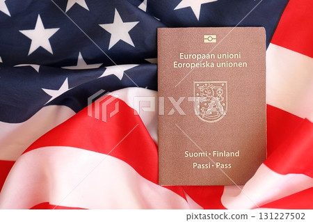 Finland passport on big waving flag of United States of America. US Visa and immigration Finland passport on big waving flag of United States of America. US Visa and immigration 131227502