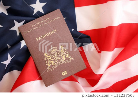 Netherlands passport on big waving flag of United States of America. US Visa and immigration Netherlands passport on big waving flag of United States of America. US Visa and immigration 131227503