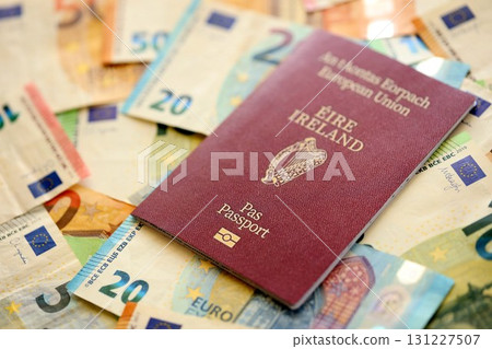 Ireland passport lies on big amount of euro money banknotes. Rich life and travel in Europe 131227507