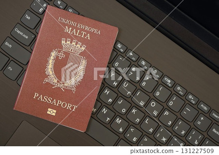 Malta passport lies on black laptop keyboard buttons background . Technologies in Europe Malta passport lies on black laptop keyboard buttons background . Technologies in Europe 131227509