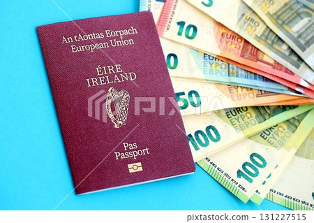 Ireland passport lies with euro money banknotes on blue background. Salary and pension in Europe 131227515