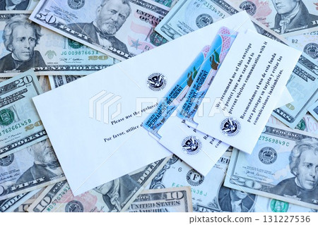 Permanent resident green cards and envelope lies on many dollar bills 131227536