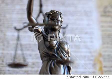 Lady Justice bronze statue and US Constitution blurred page close up. Lawsuit and justice in US 131227543