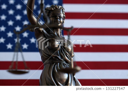 The statue of justice Themis or Justitia, the blindfolded goddess of justice against a flag of the United States of America 131227547