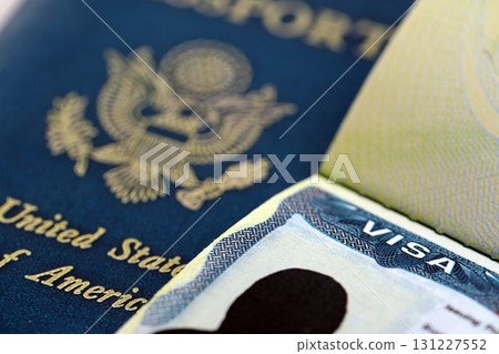 USA visa in an open passport page and United States passport cover on background 131227552