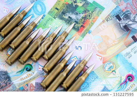 Kuwaiti dinar currency money bills and rifle bullets. The concept of warfare and gun selling Kuwaiti dinar currency money bills and rifle bullets. The concept of warfare and gun selling 131227595