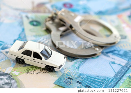 Bahraini dinar currency money bills and toy car with handcuffs. The concept of car accident Bahraini dinar currency money bills and toy car with handcuffs. The concept of car accident 131227621