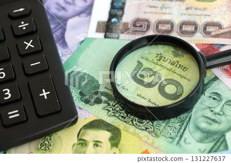 Thai baht currency money bills and calculator with magnifying glass. The concept of taxation 131227637