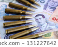 Thai baht currency money bills and rifle bullets. The concept of warfare and gun selling 131227642