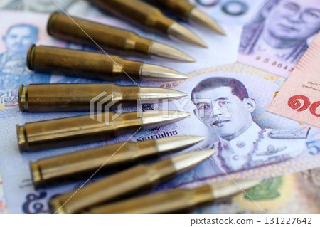 Thai baht currency money bills and rifle bullets. The concept of warfare and gun selling 131227642