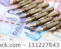 Thai baht currency money bills and rifle bullets. The concept of warfare and gun selling 131227643