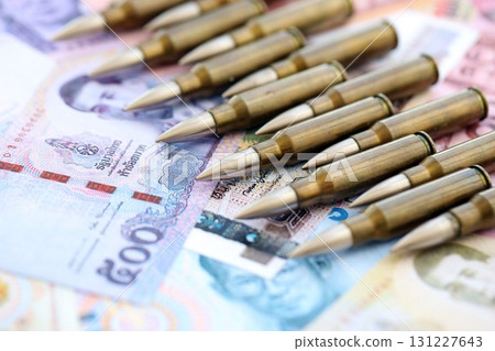 Thai baht currency money bills and rifle bullets. The concept of warfare and gun selling 131227643