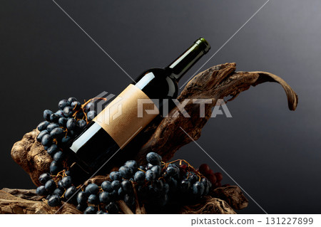 Bottle of red wine with empty label on a old snags. 131227899