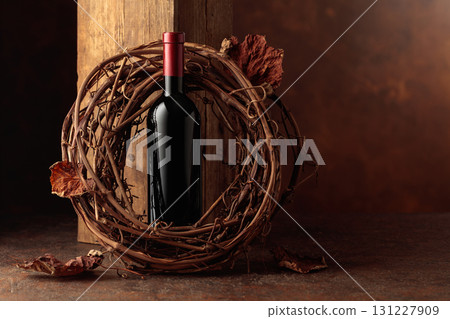 Bottle of red wine and dried grapevine wreath. Bottle of red wine and dried grapevine wreath. 131227909