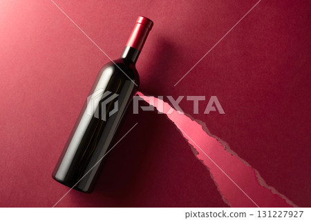 Bottle of red wine on a red paper background. 131227927