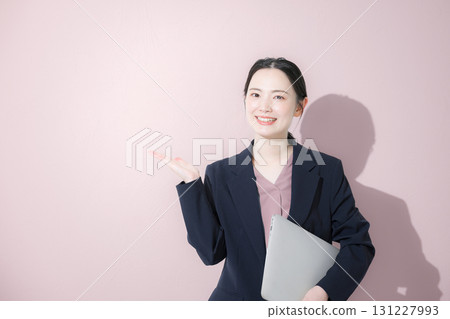 一位身穿西裝、手持筆記型電腦的年輕可愛女性的商務上半身 131227993