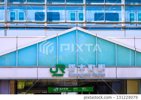 View of the cityscape of Yokohama, Japan, including Sakuragicho Station. You can see the trains on the platform. The Ferris wheel and gondolas are reflected in the station windows. View of the cityscape of Yokohama, Japan, including Sakuragicho Station. You can see the trains on the platform. The Ferris wheel and gondolas are reflected in the station windows. 131228079
