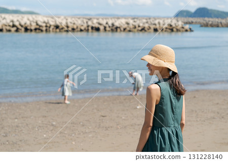 沙灘上玩耍的孩子和戴著草帽的女人 131228140