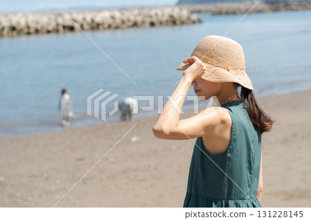 沙灘上玩耍的孩子和戴著草帽的女人 131228145