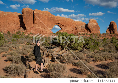 Asian male tourist standing at North Window in Arches National Park, Utah, USA 131228434