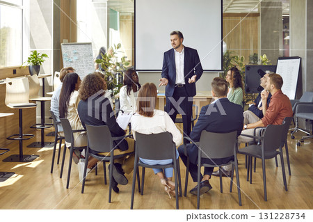 Serious business group leader instructing team, telling project strategy and presenting tasks. Serious business group leader instructing team, telling project strategy and presenting tasks. 131228734