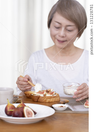 Senior woman eating bread for breakfast out of focus 131228781
