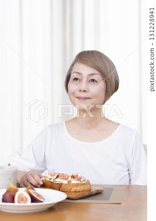 Senior woman eating bread for breakfast Senior woman eating bread for breakfast 131228941