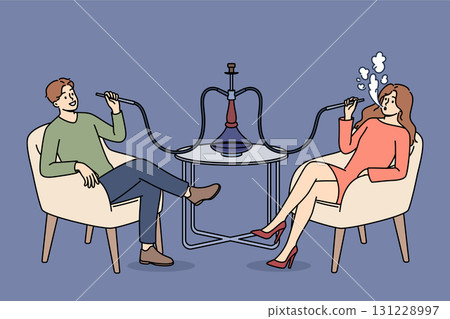 Man and woman smoke turkish hookah, sitting at table in bar and enjoying taste of tobacco Man and woman smoke turkish hookah, sitting at table in bar and enjoying taste of tobacco 131228997