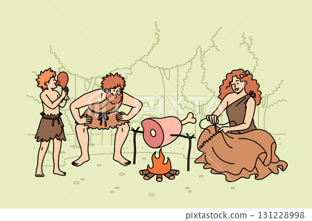 Family primitive people stands around fire in forest, roasting meat for dinner or sewing up clothes Family primitive people stands around fire in forest, roasting meat for dinner or sewing up clothes 131228998